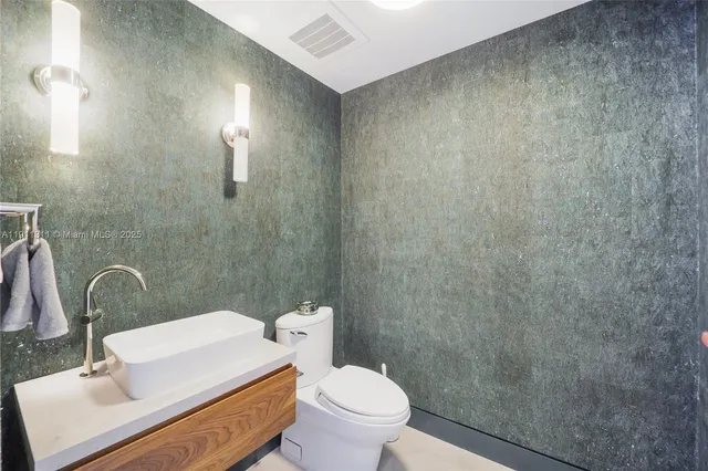 a white toilet sitting next to a bathroom sink