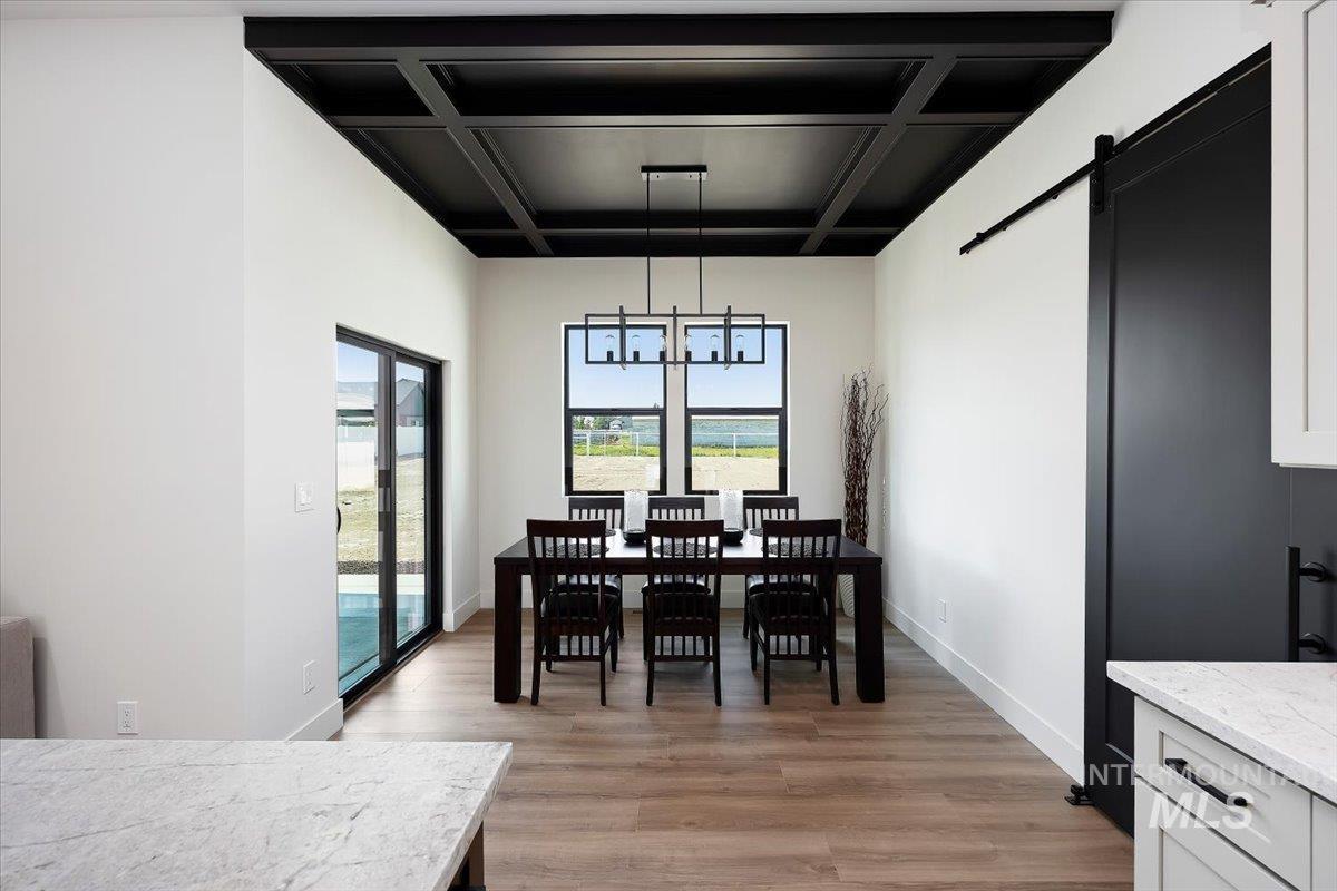 3068 Moonrise Road Twin Falls, ID 83301 - Photo 15 of 43 White paneled accent wall, black-framed window, wood-finish flooring, white baseboards, and bright white walls
