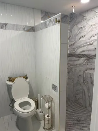 a bathroom with a toilet and a shower