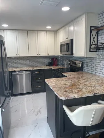 a kitchen with stainless steel appliances granite countertop a sink counter space and cabinets
