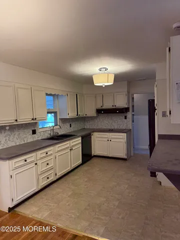 a kitchen with granite countertop a refrigerator and a stove top oven