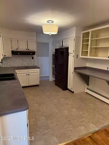 a kitchen with granite countertop a sink a stove and cabinets
