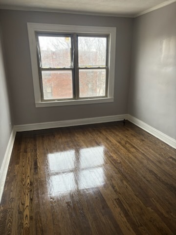 1248 West 83rd Street, Unit 1 Chicago, IL 60620 - Photo 2 of 7 an empty room with wooden floor and windows