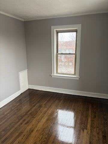 1248 West 83rd Street, Unit 1 Chicago, IL 60620 - Photo 3 of 7 a view of an empty room with wooden floor and a window