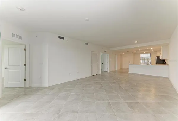 a large kitchen with stainless steel appliances granite countertop a sink a stove a refrigerator cabinets and living room view