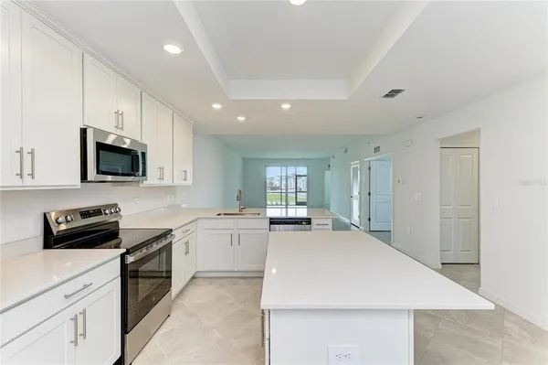 a kitchen with stainless steel appliances white cabinets and a stove top oven