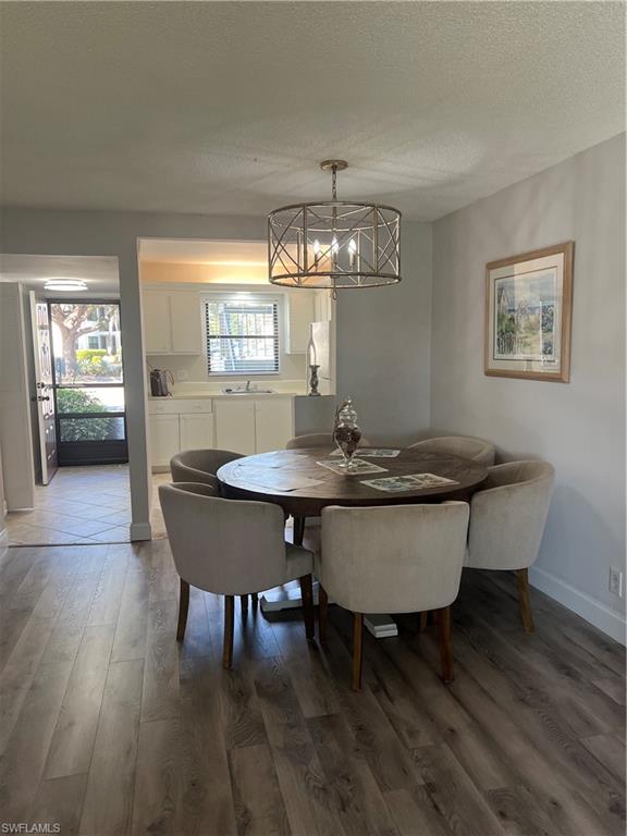 4346 27th Court Southwest, Unit 102 Naples, FL 34116 - Photo 11 of 15 a view of a dining room with furniture and wooden floor