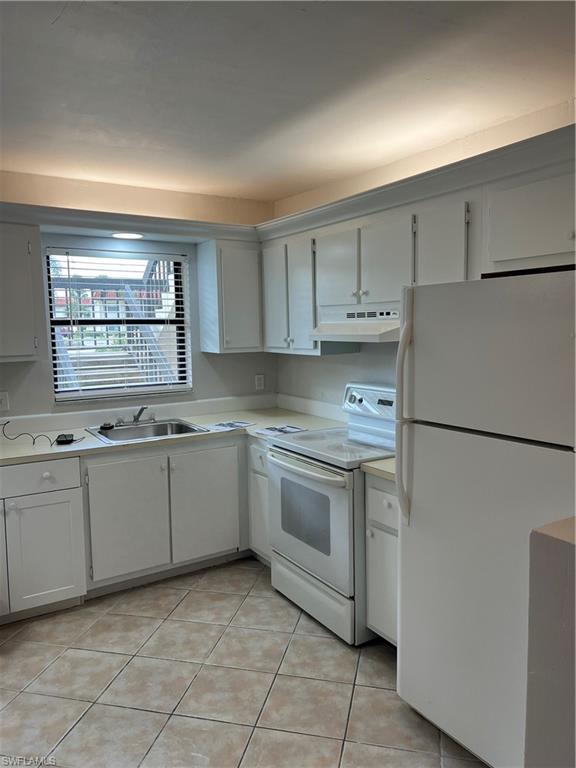 4346 27th Court Southwest, Unit 102 Naples, FL 34116 - Photo 3 of 15 a kitchen with granite countertop cabinets appliances a sink and a window
