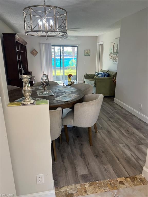 4346 27th Court Southwest, Unit 102 Naples, FL 34116 - Photo 6 of 15 a view of a dining room with furniture a chandelier and wooden floor
