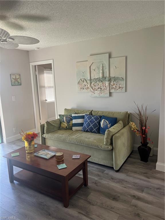 4346 27th Court Southwest, Unit 102 Naples, FL 34116 - Photo 8 of 15 a living room with furniture and wooden floor