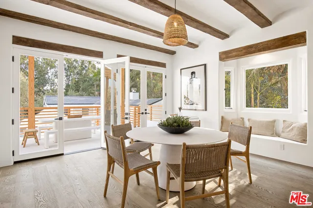 a view of a dining room with furniture large windows and wooden floor