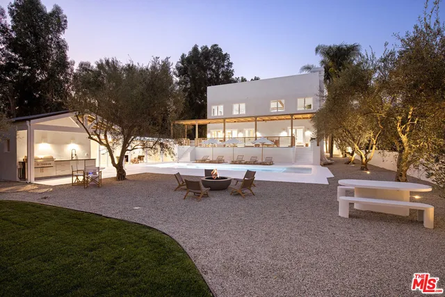 a backyard of a house with table and chairs