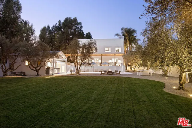 a large green field with lots of trees