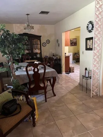 a living room with furniture a chandelier and a dining table