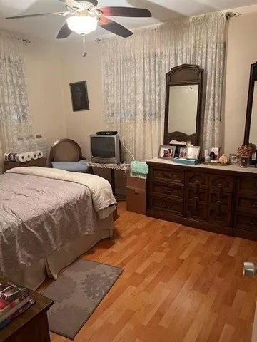 a bedroom with a bed and a mirror on the dresser