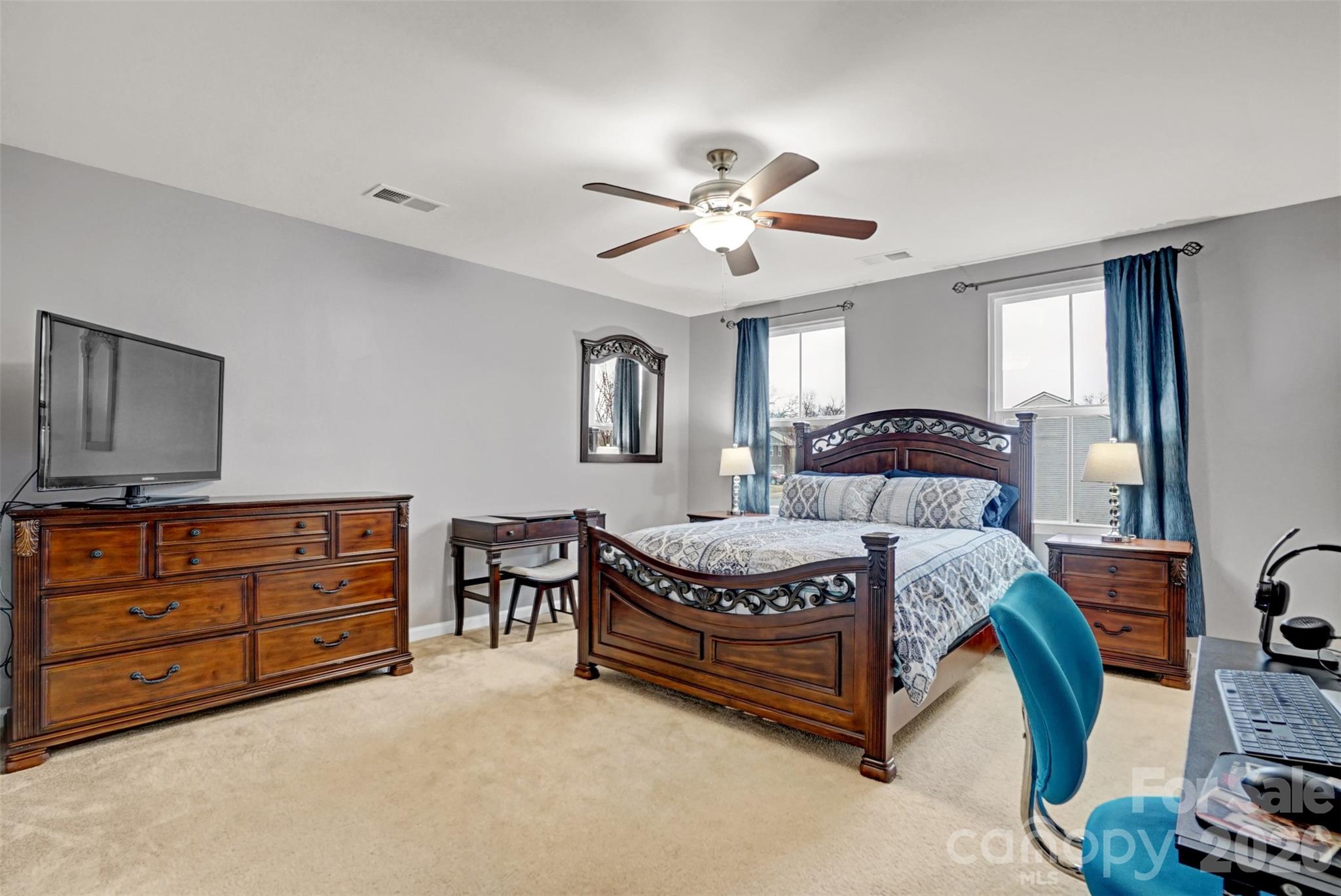 1144 Tangle Ridge Drive Southeast Concord, NC 28025 - Photo 14 of 27 a spacious bedroom with a bed a dresser and a chandelier