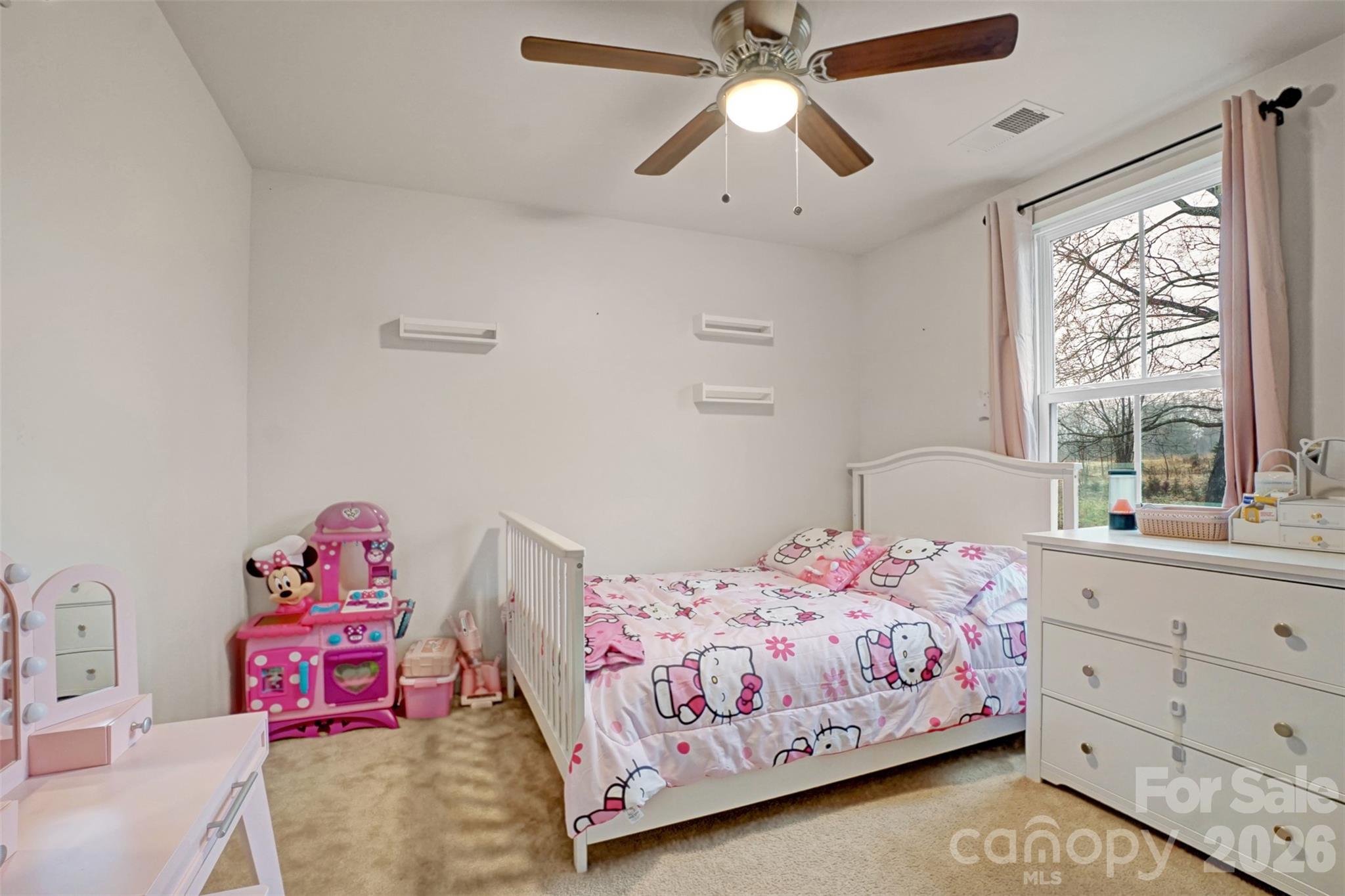 1144 Tangle Ridge Drive Southeast Concord, NC 28025 - Photo 18 of 27 a bedroom with two beds and a chandelier