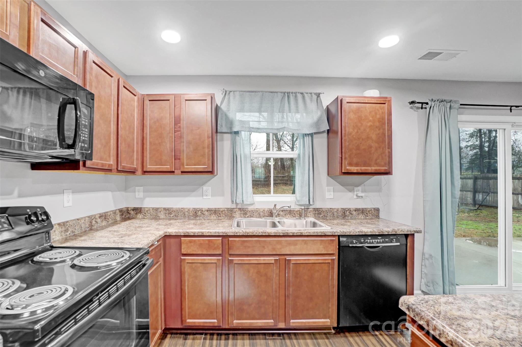 1144 Tangle Ridge Drive Southeast Concord, NC 28025 - Photo 9 of 27 a kitchen with stainless steel appliances granite countertop a sink stove and cabinets