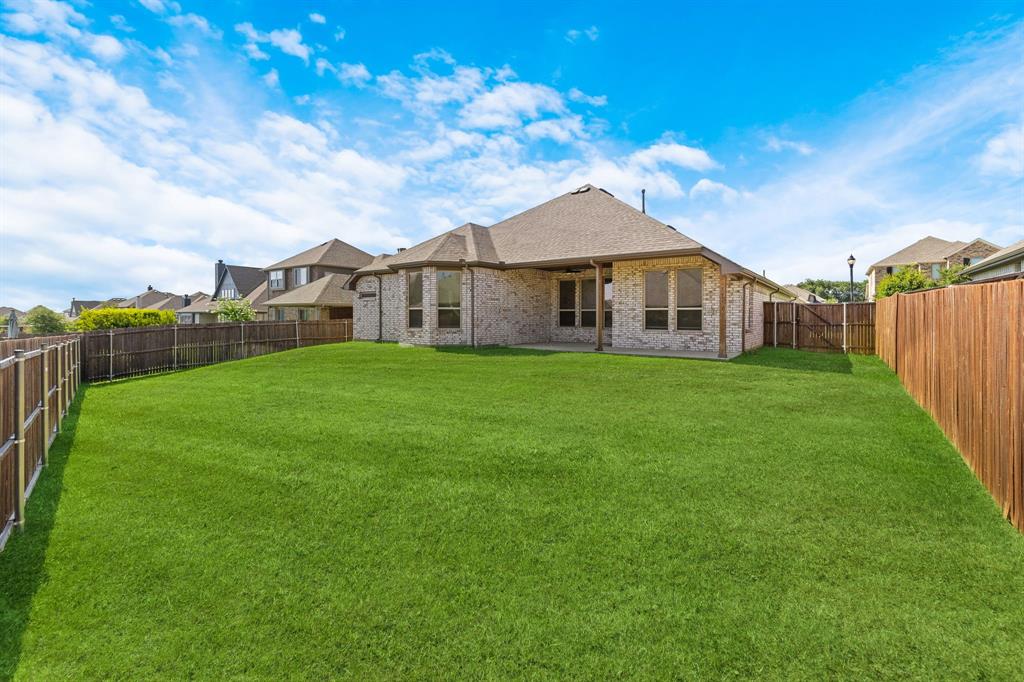 915 Timber Ridge Drive Justin, TX 76247 - Photo 36 of 39 Expansive green lawn with a privacy fence