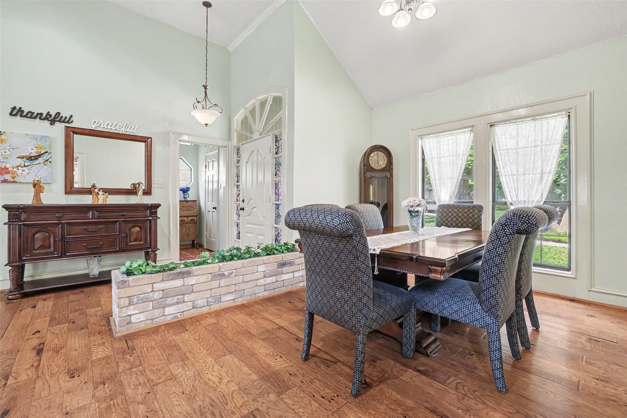 110 South Ridge Circle Georgetown, TX 78628 - Photo 8 of 37 Vaulted ceilings with a decorative chandelier, wood-finish flooring, and natural light from large windows