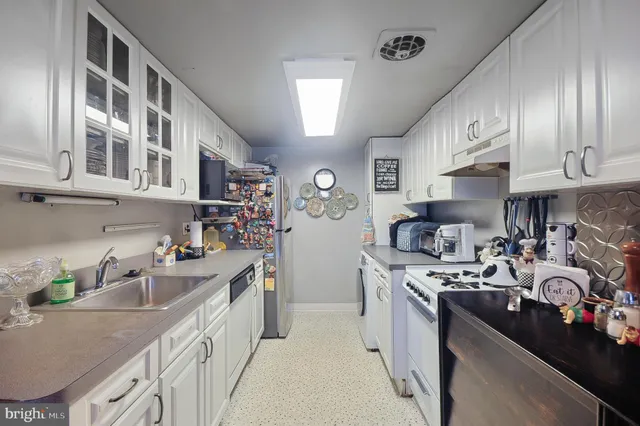 a kitchen with stainless steel appliances granite countertop a sink stove and cabinets