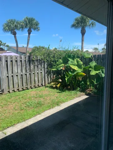 a view of a livingroom with a chandelier fan and windows