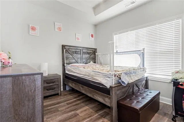 a bedroom with a bed and a dresser next to a window