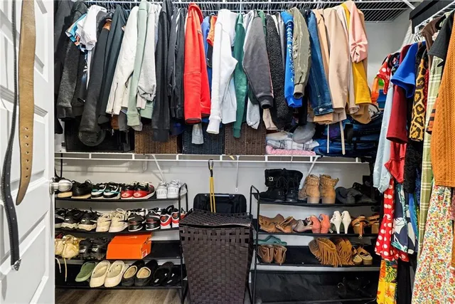 a view of walk in closet with clothes and shoes