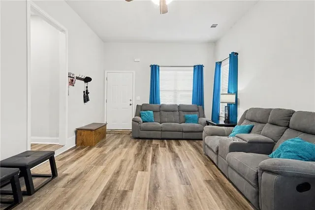 a living room with furniture and a wooden floor