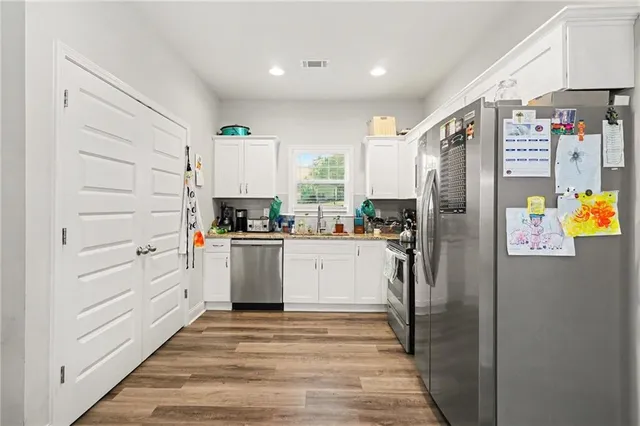 a kitchen with refrigerator and cabinets
