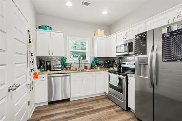 a kitchen with stainless steel appliances granite countertop a refrigerator a sink a stove a microwave and island