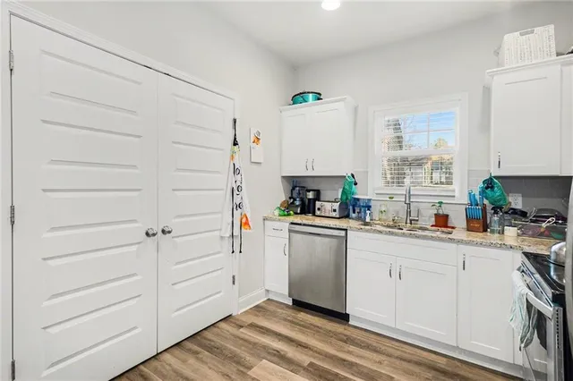 a kitchen with granite countertop white cabinets and white appliances