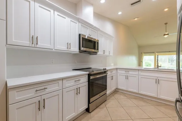a kitchen with white cabinets stainless steel appliances and sink