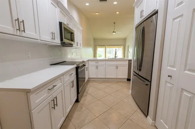 a kitchen with stainless steel appliances granite countertop a refrigerator and a stove top oven
