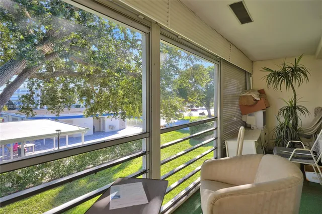 a view of a porch with furniture and a yard