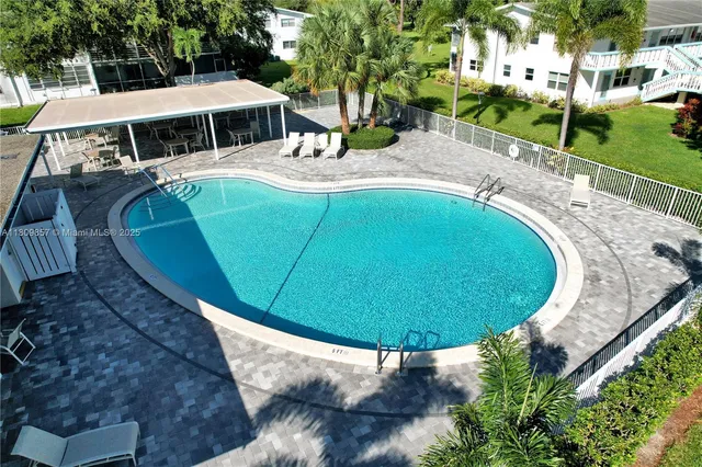 a view of a swimming pool with a yard and sitting area