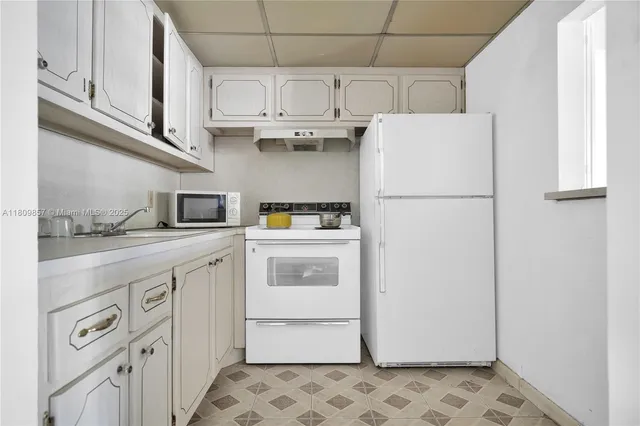 a kitchen with stainless steel appliances a refrigerator sink and cabinets
