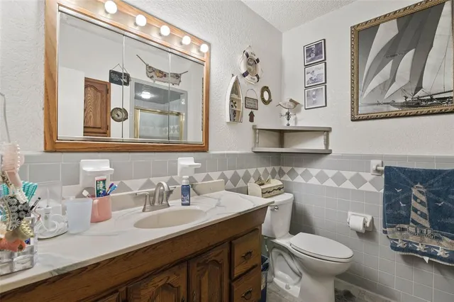a bathroom with a granite countertop toilet sink and mirror