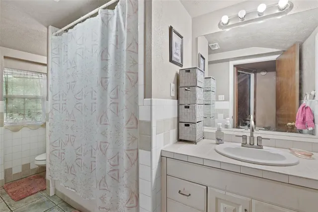 a bathroom with a granite countertop sink a toilet and a mirror