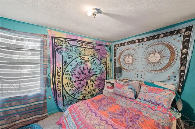 a bedroom with a bed and painting on the wall