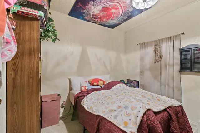 a bedroom with a bed and a painting on the wall