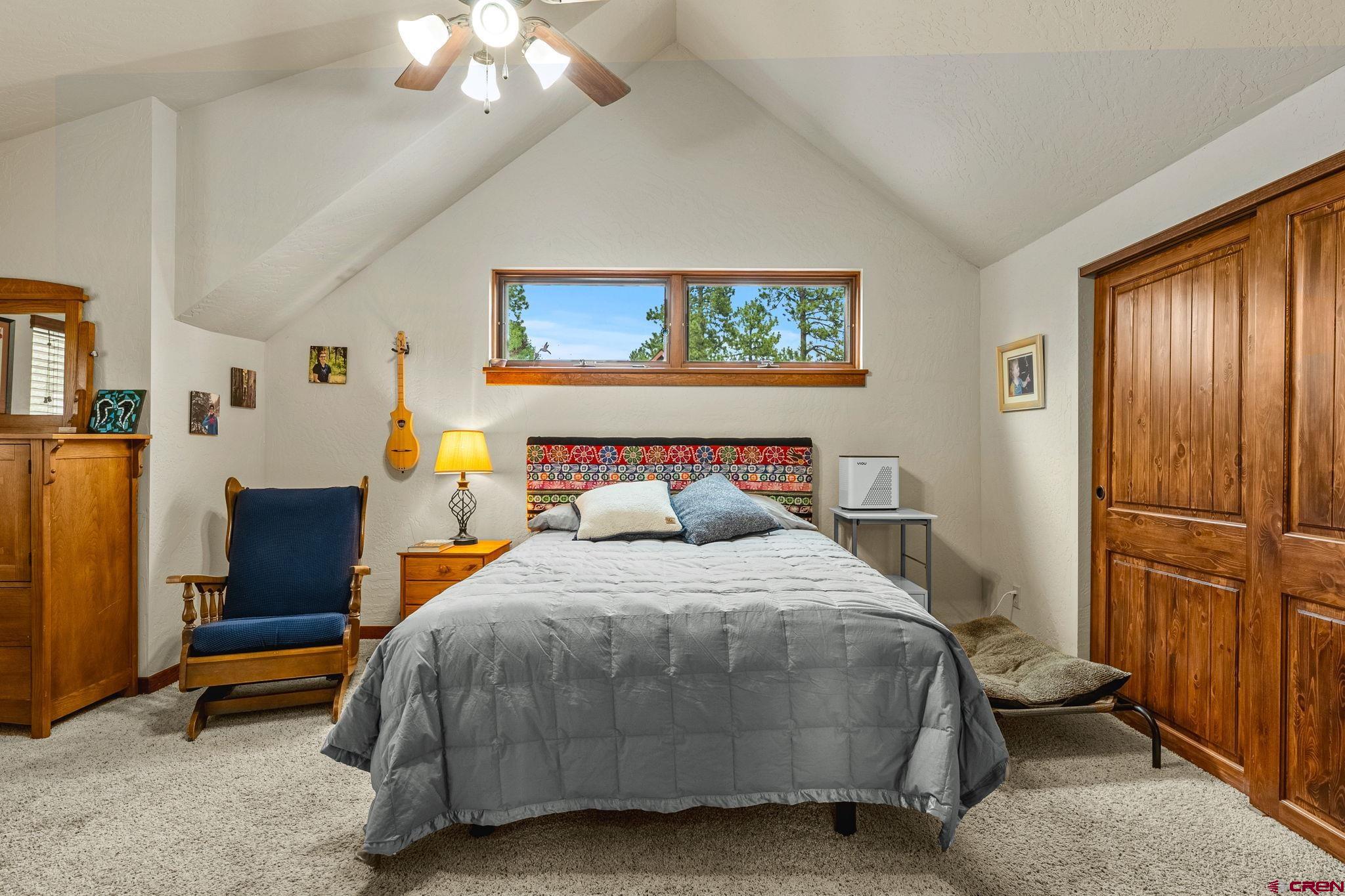 141 Red Canyon Trail, Unit E Durango, CO 81301 - Photo 15 of 42 a bedroom with a bed and a chandelier