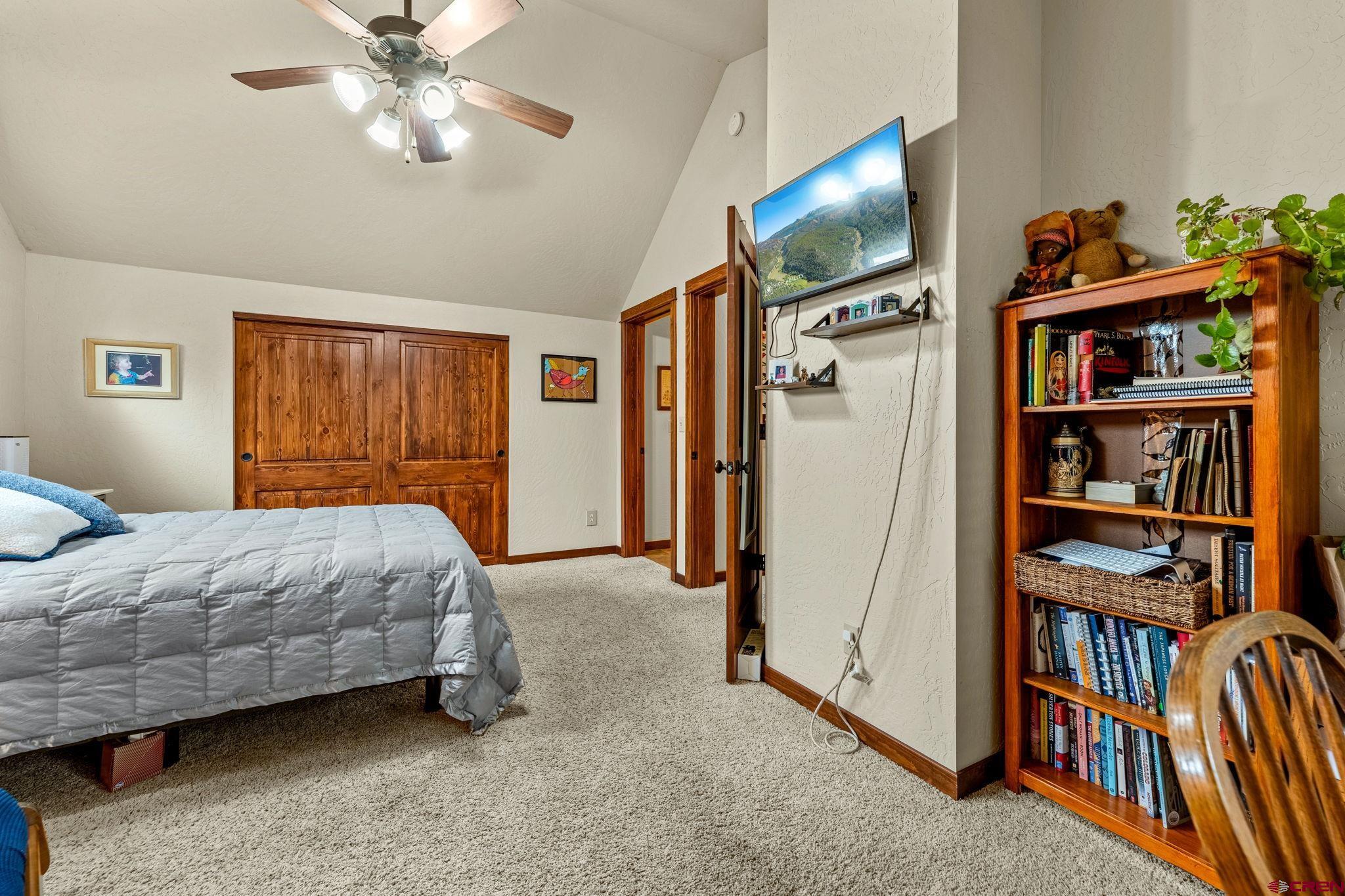 141 Red Canyon Trail, Unit E Durango, CO 81301 - Photo 17 of 42 a bedroom with a bed a book shelf and a window