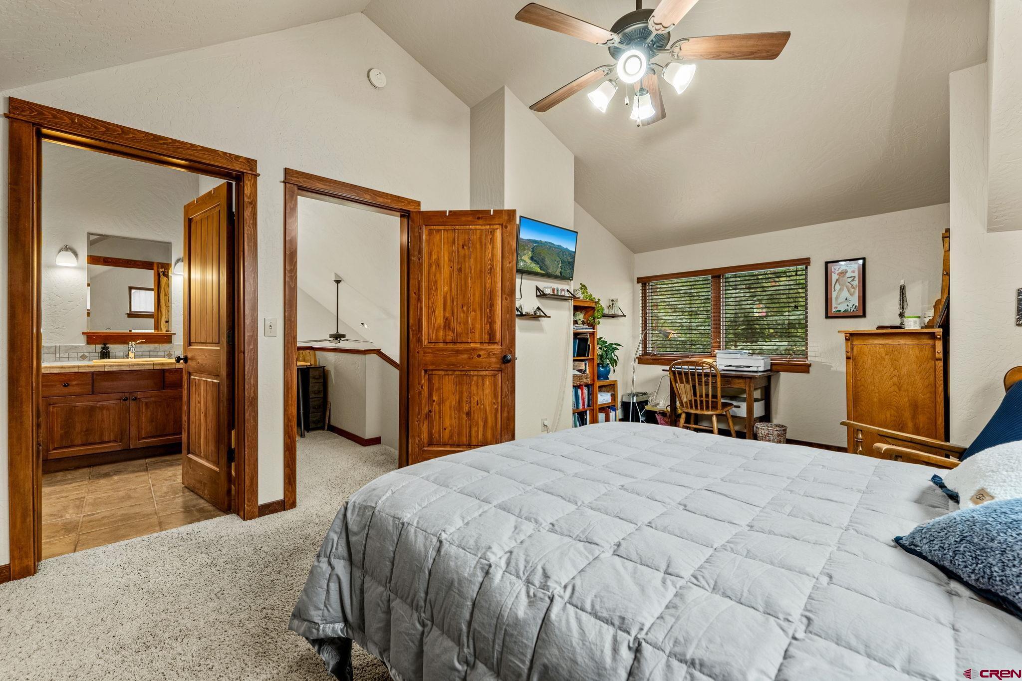 141 Red Canyon Trail, Unit E Durango, CO 81301 - Photo 18 of 42 a bedroom with a bed and a large mirror with a chandelier