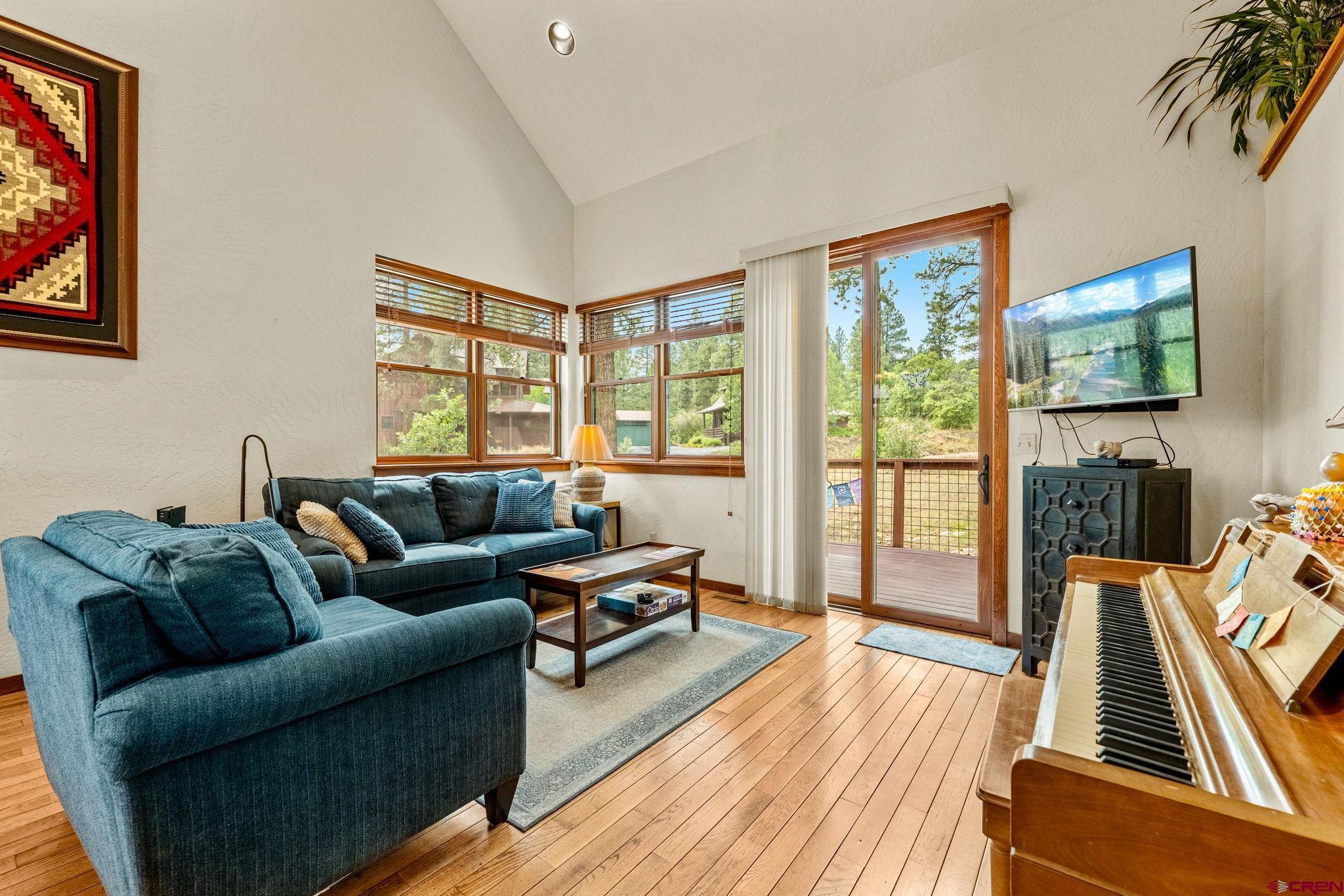 141 Red Canyon Trail, Unit E Durango, CO 81301 - Photo 6 of 42 a living room with furniture a flat screen tv and a floor to ceiling window