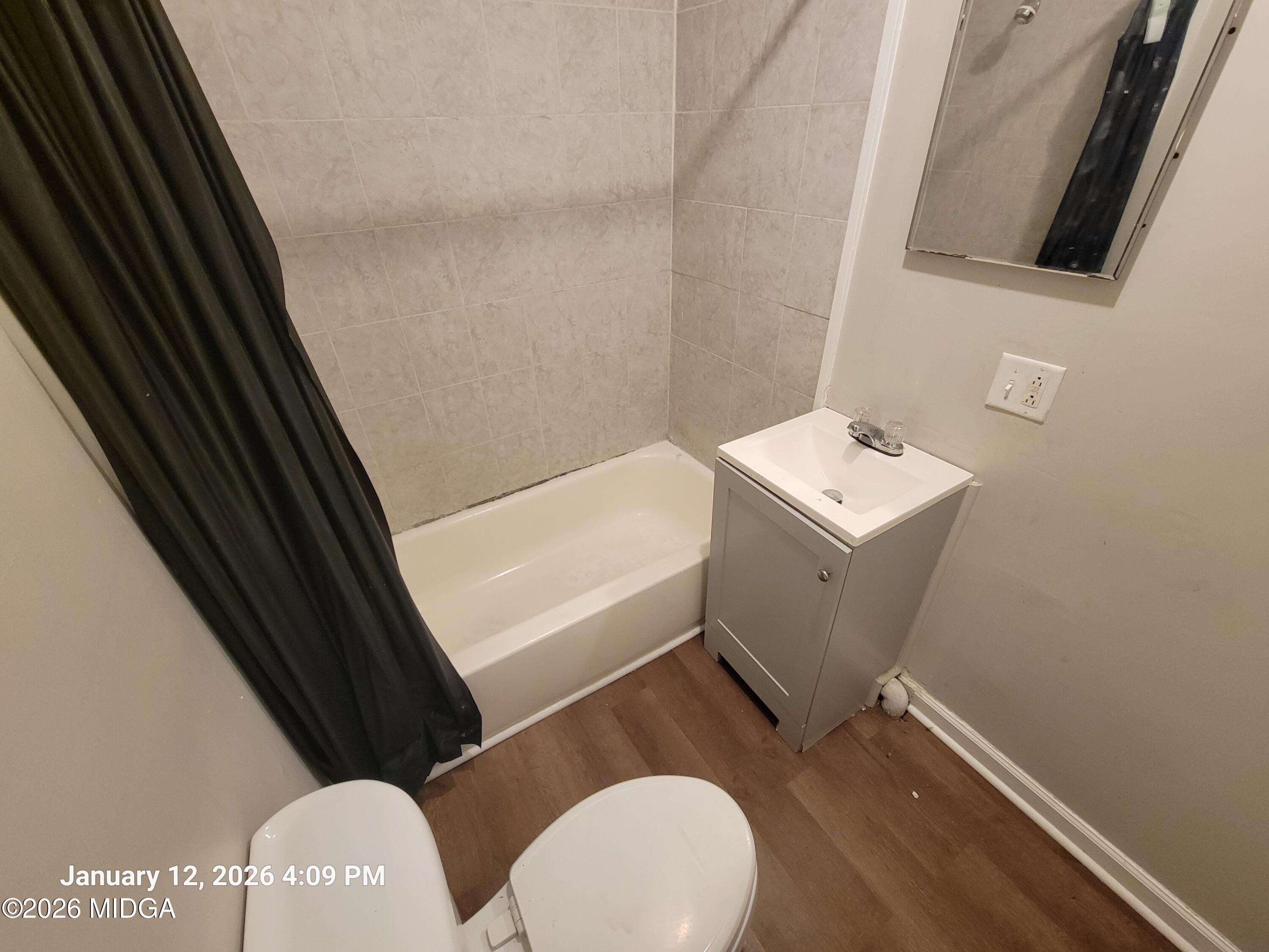 2872 Antioch Road Macon, GA 31206 - Photo 4 of 12 a bathroom with a sink a toilet a mirror and vanity