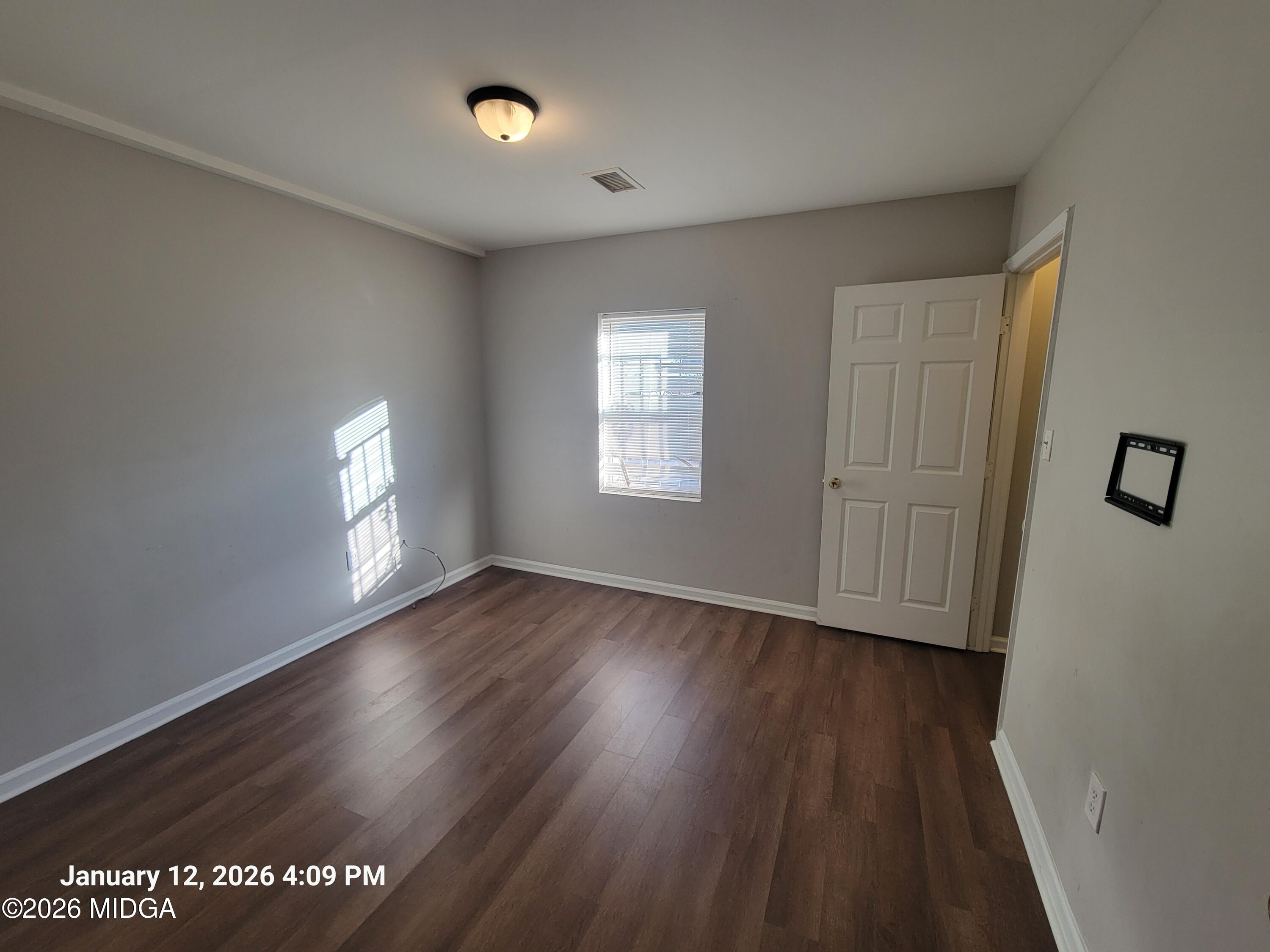 2872 Antioch Road Macon, GA 31206 - Photo 6 of 12 an empty room with wooden floor and windows