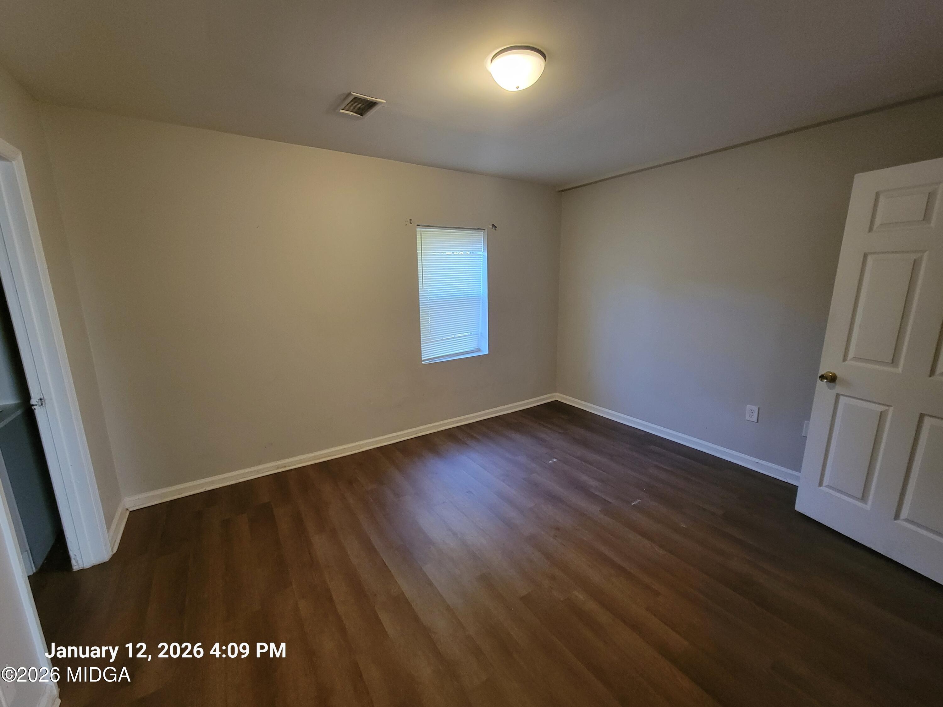 2872 Antioch Road Macon, GA 31206 - Photo 7 of 12 an empty room with wooden floor and window