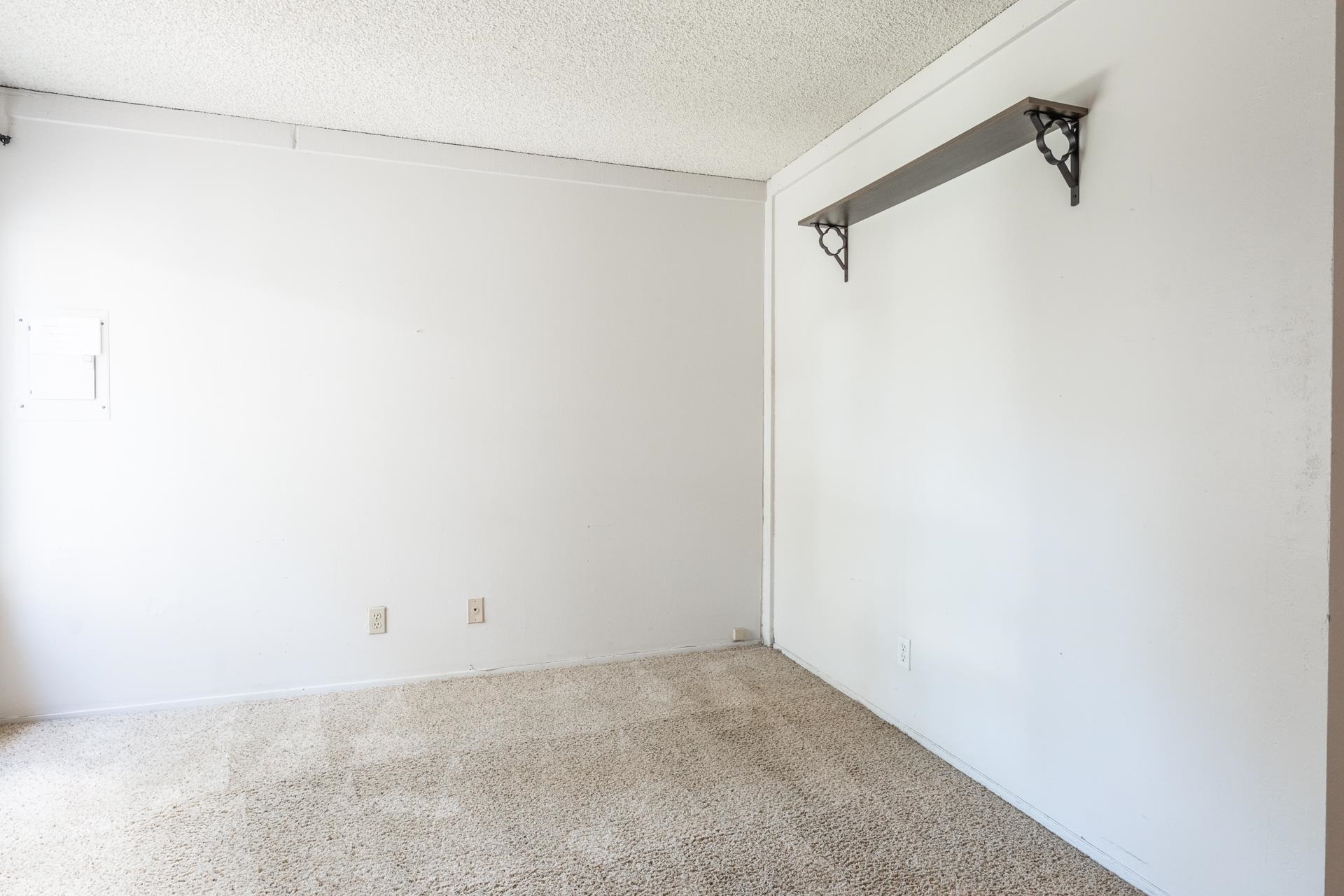362 Old Mammoth Road, Unit 59 Mammoth Lakes, CA 93546 - Photo 20 of 35 White painted walls, textured ceiling, brown carpeting, and a built-in wall shelf with decorative brackets