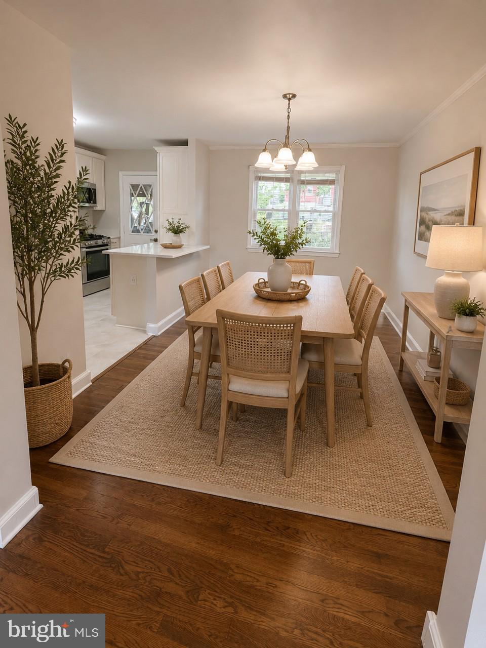 5649 Utrecht Road Baltimore, MD 21206 - Photo 10 of 42 a dining room with wooden floor a chandelier a wooden table and chairs